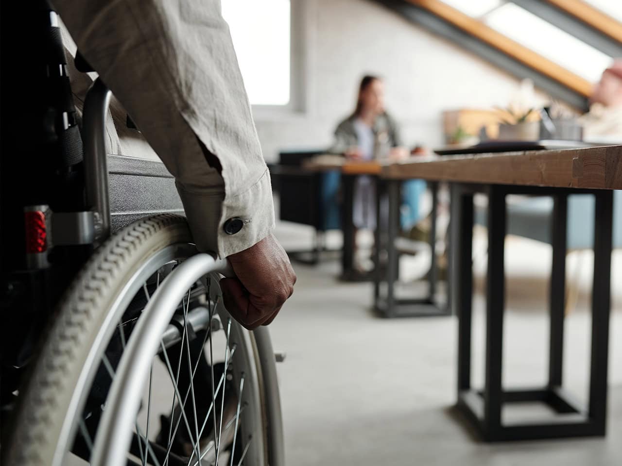 Man in wheelchair going into a casual meeting