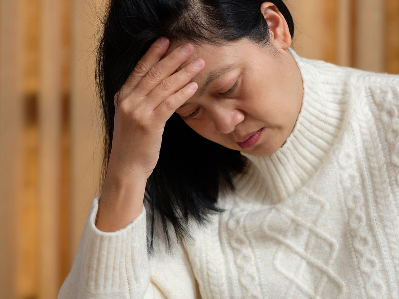 stressed woman rubbing her head