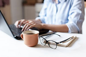 Picture of a person sitting at a desk working on their computer