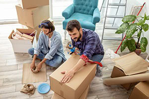 Picture of a couple packing boxes in their house to move