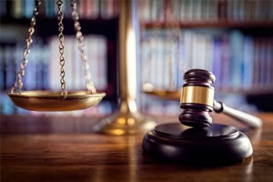 gavel and scales of justice on desk in office with a library