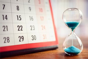 Calendar and hourglass on a table