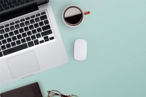 Office desk with laptop, coffee and notebook