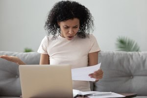 Woman sitting on couch reading a letter