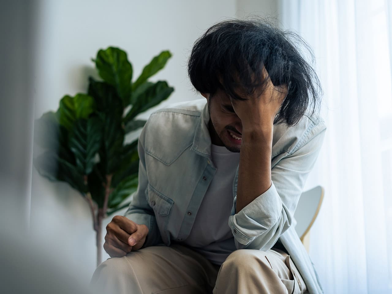 man is depressed while sitting in a chair