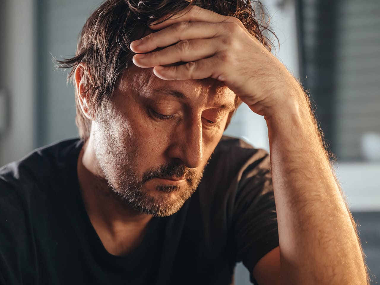 middle aged man holding his head