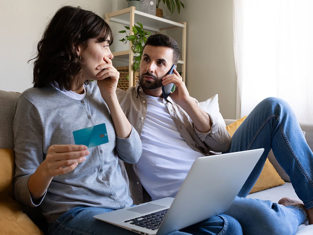 Concerned couple with credit card while on phone