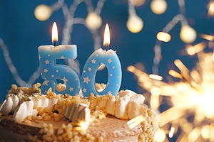 Picture of a birthday cake with blue "50" candles