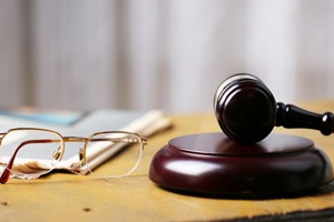 gavel on desk with glasses and book