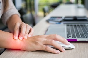 Person working on computer with arthritis
