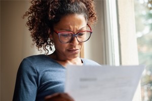 Picture of a woman looking stressed reading a document