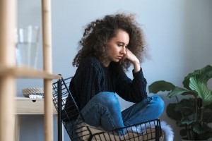Picture of a young woman sitting in a chair looking upset