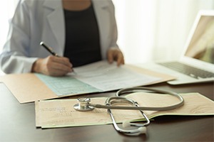 female-doctor-reviewing-medical-record-at-desk